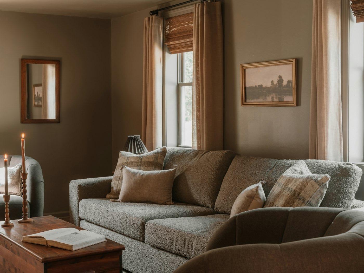 A cozy living room with a sofa and armchair in warm afternoon light